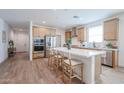 Bright, open kitchen with a large center island, stainless steel appliances and wood-look flooring at 10964 W Garfield St, Avondale, AZ 85323