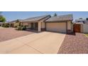 A single-Gathering home with a long driveway leading to an attached two-car garage, and xeriscaped front yard at 1165 E Ivanhoe St, Chandler, AZ 85225