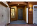 Inviting entryway featuring a gray front door, decorative lighting, and a charming window at 13145 W Whisper Rock Trl, Peoria, AZ 85383