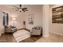 Bright sitting room with plantation shutters, two comfortable armchairs, and elegant decor at 13145 W Whisper Rock Trl, Peoria, AZ 85383
