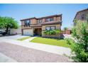Attractive two-story home with lush landscaping and a tile roof, creating curb appeal at 13601 W Hearn Rd, Surprise, AZ 85379