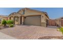 Inviting home exterior with a brick-paved driveway and a two-car garage at 15078 W Mckinley St, Goodyear, AZ 85338