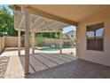 Backyard patio offering a view of the pool with a rock waterfall, lush desert landscaping, and privacy at 16126 N 159Th Dr, Surprise, AZ 85374