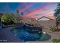 Backyard pool with stacked stone waterfall feature offers a serene outdoor retreat at 16425 S 34Th St, Phoenix, AZ 85048