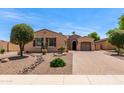 Charming single-story home with desert landscaping, brick driveway, and barrel roof accents at 1643 N 144Th Dr, Goodyear, AZ 85395