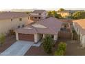 Aerial view of a well-kept house in a residential area with a two-car garage and tiled roof at 18344 W Getty Dr, Goodyear, AZ 85338