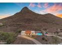 This aerial shows a single-story home with a red tile roof and refreshing pool in a mountain community at 1917 E Karen Dr, Phoenix, AZ 85022