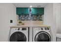 Efficient laundry room with stacked washer/dryer and stylish floral wallpaper at 2455 E Broadway Rd # 122, Mesa, AZ 85204