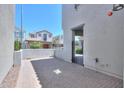 View of a brick-paved backyard featuring a metal gate and white perimeter wall at 281 E Shamrock Dr, Chandler, AZ 85286