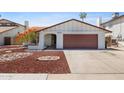 Charming single-story home featuring a well-manicured yard with unique rock landscaping and a two car garage at 3021 E Harmony Cir, Mesa, AZ 85204