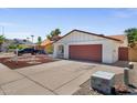 Charming single-story home featuring a well-manicured yard with unique rock landscaping and a two car garage at 3021 E Harmony Cir, Mesa, AZ 85204