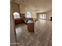 Open-concept kitchen with granite countertops, tile flooring, breakfast bar, and stainless steel appliances at 3853 W Calle Lejos --, Glendale, AZ 85310