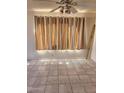 Bright room featuring tile flooring, large windows with curtains, and a ceiling fan at 3853 W Calle Lejos --, Glendale, AZ 85310