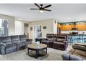 Comfortable living room showcasing plush seating and an open floor plan to the kitchen at 42711 W Darter Dr, Maricopa, AZ 85138