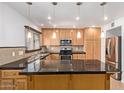An open kitchen featuring black countertops, wood cabinets, stainless steel appliances, and a kitchen island at 4629 S Mill Ave, Tempe, AZ 85282