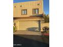 Two-car garage with a neutral door, framed windows above, and a landscaped yard at 4743 W Alice Ave, Glendale, AZ 85302