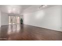 Spacious living room with sliding glass doors to the outside patio, hardwood floors and white walls at 611 E Colgate Dr, Tempe, AZ 85283