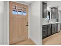 Modern kitchen featuring sleek gray cabinets, white countertops, and a stylish wood door to the exterior at 6908 E Windsor Ave, Scottsdale, AZ 85257