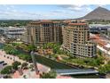 Beautiful exterior shot of two luxury condos with lush landscaping, water features, and a pedestrian bridge at 7181 E Camelback Rd # 702, Scottsdale, AZ 85251