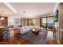 Bright living room with hardwood floors, fireplace, open floorplan, and balcony access at 7181 E Camelback Rd # 702, Scottsdale, AZ 85251