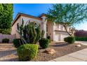 Attractive two-story home with desert landscaping, a three-car garage, and arched windows at 7247 W Buckskin Trl, Peoria, AZ 85383
