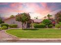 Beautiful front lawn with healthy green grass, mature trees, and decorative bushes at 7722 W Michigan Ave, Glendale, AZ 85308