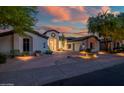 Beautiful front exterior displaying meticulous landscaping, rock features, and desert foliage at 7775 E Fledgling Dr, Scottsdale, AZ 85255