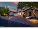 The front exterior of the home shows a circular window feature and manicured desert landscaping at 7775 E Fledgling Dr, Scottsdale, AZ 85255