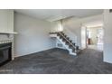 Inviting living room showcasing a cozy fireplace, staircase, and plush carpet at 8111 W Wacker Rd # 94, Peoria, AZ 85381