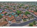 A neighborhood view of many single-Gathering homes, lush greenery, and community streets from an aerial perspective at 927 N Somerset Cir, Mesa, AZ 85205