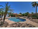 Backyard pool view with palm trees, a patio area, lush landscaping, and plenty of space for outdoor enjoyment at 927 N Somerset Cir, Mesa, AZ 85205
