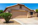 Well-maintained single-story home with a two-car garage, desert landscaping, and a trimmed green bush at 10934 W Almeria Rd, Avondale, AZ 85392