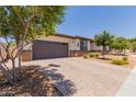 Inviting single-story home with a two-car garage, desert landscaping, and a brick-paved driveway at 1166 W Silver Creek Ln, Queen Creek, AZ 85140
