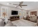 Bright, open-concept living room featuring wood floors, a ceiling fan, and ample natural light at 1166 W Silver Creek Ln, Queen Creek, AZ 85140