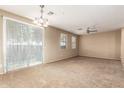Bright living room featuring neutral carpeting, ceiling fan, and large sliding glass door at 1250 S Rialto -- # 78, Mesa, AZ 85209