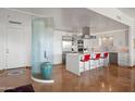 Open-concept kitchen with stainless appliances, a waterfall island with seating, and statement glass wall at 17 W Vernon Ave # 508, Phoenix, AZ 85003