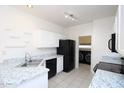 Kitchen features white cabinets, granite countertops, black appliances, and tile flooring at 17606 N 17Th Pl # 1096, Phoenix, AZ 85022