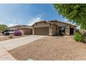 Charming single-story home with neutral stucco, tile roof, desert landscaping and a spacious two-car garage at 17828 W Calavar Rd, Surprise, AZ 85388