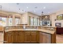 Open kitchen featuring custom cabinets, granite countertops, and stainless steel appliances at 18029 W San Miguel Ave, Litchfield Park, AZ 85340