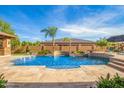 Stunning backyard pool with a waterfall feature and travertine tile surround at 18029 W San Miguel Ave, Litchfield Park, AZ 85340
