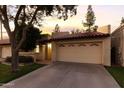 Charming home exterior at dusk showcases a well-maintained yard and a two-car garage at 2110 W Navarro Ave, Mesa, AZ 85202