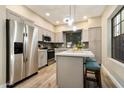 Contemporary kitchen boasts stainless steel appliances, an island with seating, and ample cabinet space at 2110 W Navarro Ave, Mesa, AZ 85202