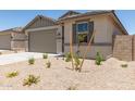A single-story home featuring a two-car garage, neutral color palette, and desert landscaping at 22913 N 183Rd Dr, Surprise, AZ 85387