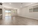Spacious living room featuring neutral color palette, recessed lighting, and sliding glass door at 22913 N 183Rd Dr, Surprise, AZ 85387