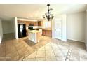 Open kitchen with an island, black appliances, tile flooring, and a chandelier at 23284 W Pima St, Buckeye, AZ 85326