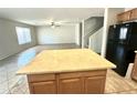 View of the kitchen island, refrigerator, and open access to the living room at 23284 W Pima St, Buckeye, AZ 85326