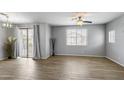 Bright living room with wood-look tile floors, neutral walls, and a sliding door to a balcony at 2941 E Darrow St, Phoenix, AZ 85042