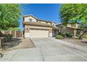 Two-story home featuring a two-car garage, stone accents, and a well-manicured front yard with a long driveway at 29828 N 72Nd Ln, Peoria, AZ 85383