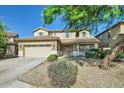 Charming two-story home featuring a two-car garage, stone accents, and a well-manicured front yard under a blue sky at 29828 N 72Nd Ln, Peoria, AZ 85383