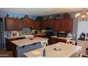 Open-concept kitchen with granite countertops, wood cabinets, and a farmhouse sink at 31138 N 130Th Ln, Peoria, AZ 85383